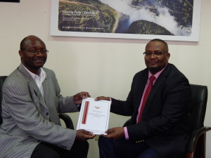 Chairperson of the Zambian Catholic Community in South Africa, Mr. Chimwemwe Mtonga presenting a copy of their constitution to His Excellency Mr. Emmanuel Mwamba. This was at the High Commissioner's office on 25th September, 2015